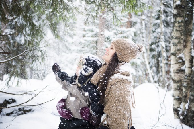 aikuinen ja lapset lumisateessa