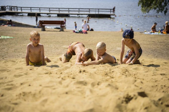 Lapsia leikkimässä hiekalla uimarannalla