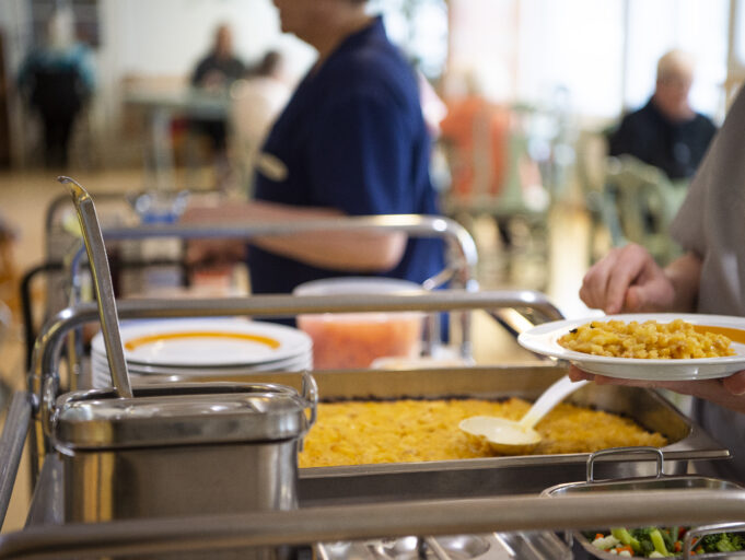 Lapsi ottaa kouluruokaa kauhalla.